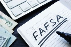 a desktop with a notebook that says fafsa