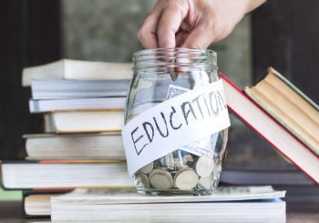 a student puts college savings money in a jar