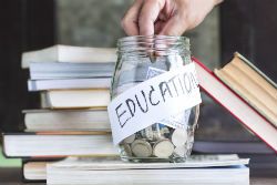 a person putting money in a jar to save for college